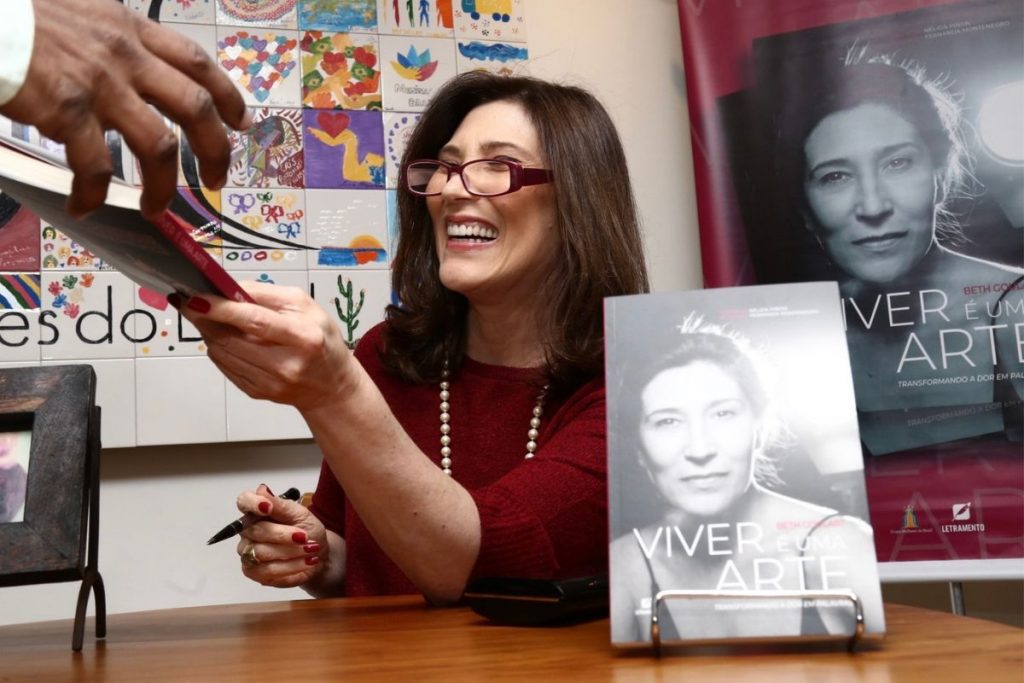 Beth Goulart posando para foto em lançamento de seu primeiro livro