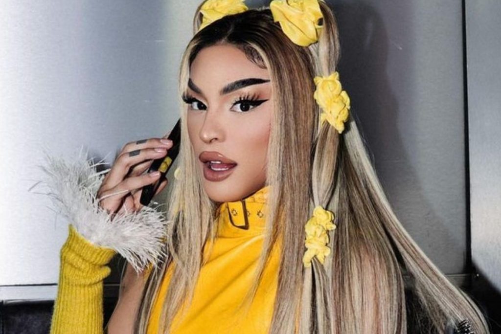 pabllo vittar levando celular ao ouvido com look amarelo de show da parada do orgulho lgbtqiap+