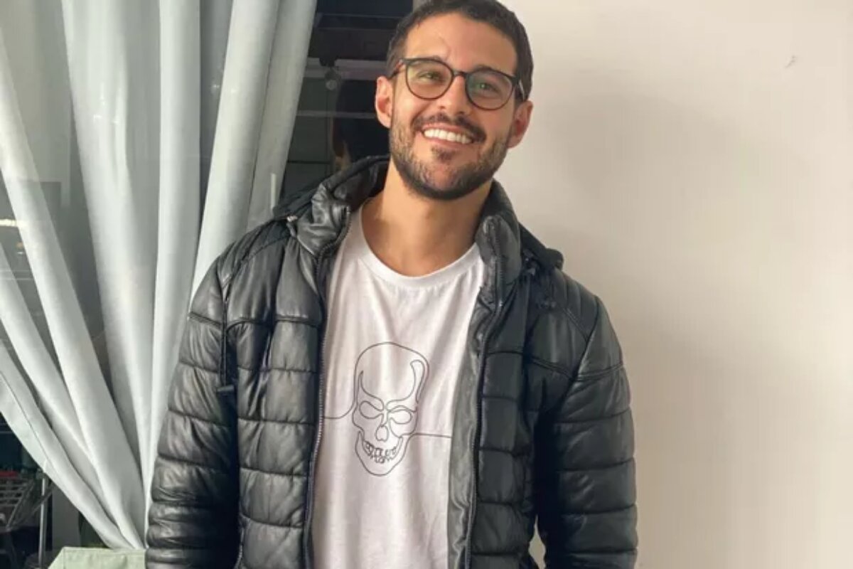 Rodrigo Mussi sorrindo de jaqueta preta e camisa branca