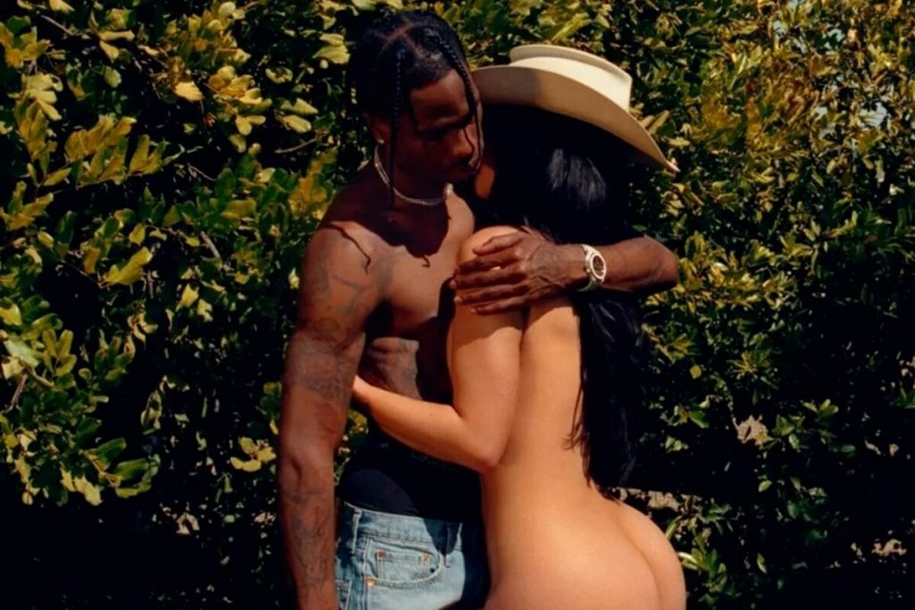 Kylie Jenner nua abraçada e beijando Travis Scott, que está sem camisa, de calça jeans