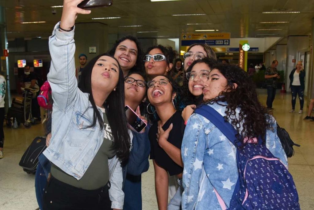 Any Gabrielly posando para foto com fãs no aeroporto