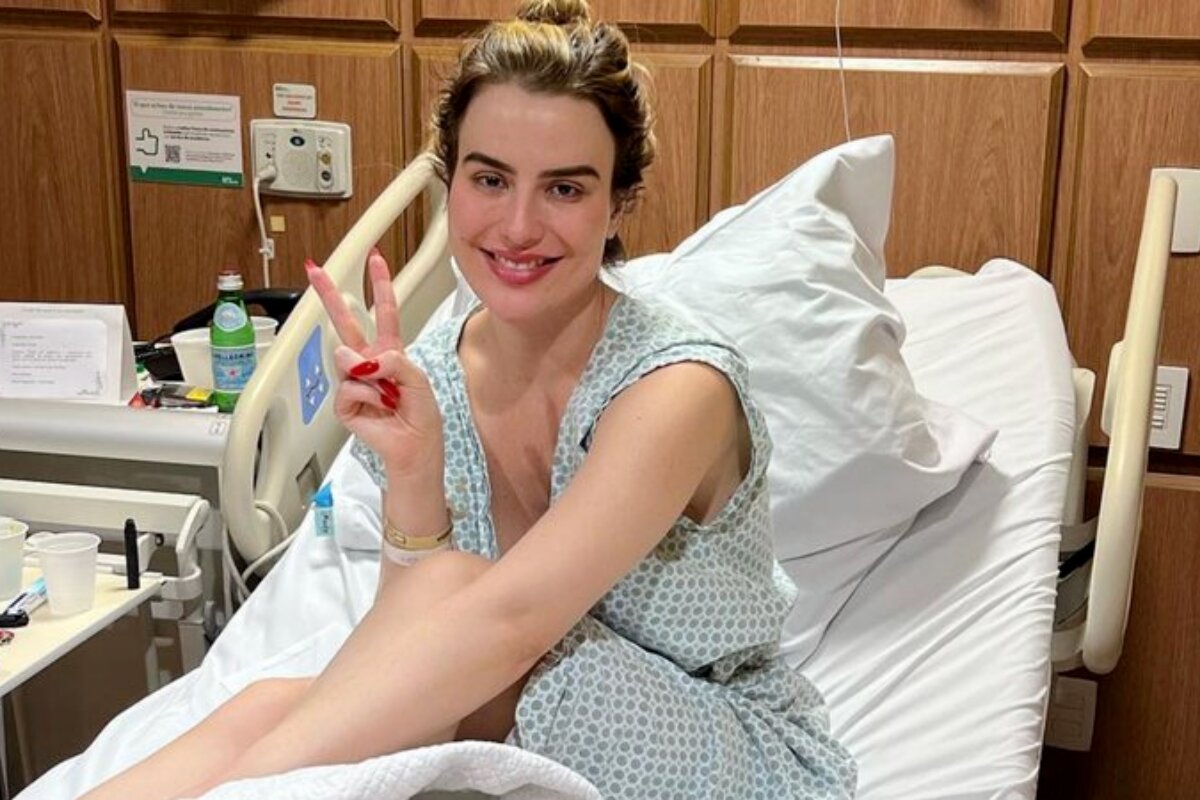 Fernanda Keulla sentada na cama do hospital, fazendo sinal de positivo. sorrindo