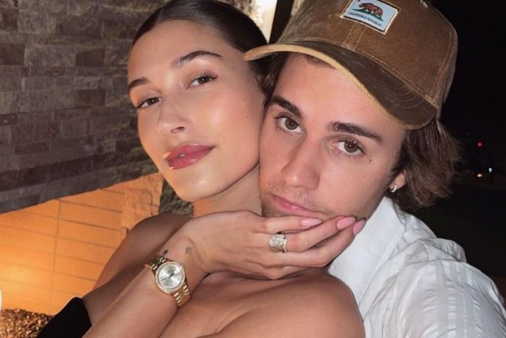 Hailey com a mão no queixo de Justin Bieber