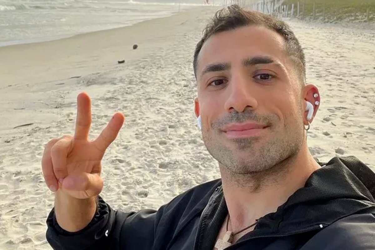 Kaysar Dadour fazendo sinal de positivo, na praia