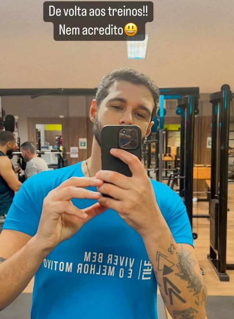 Rodrigo Mussi de camisa azul, fazendo selfie na academia