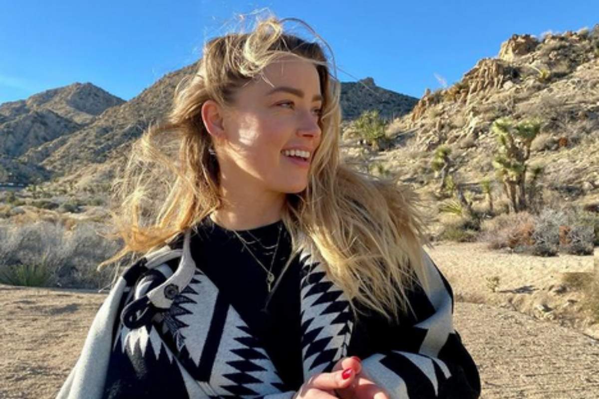 Amber Heard sorrindo no deserto