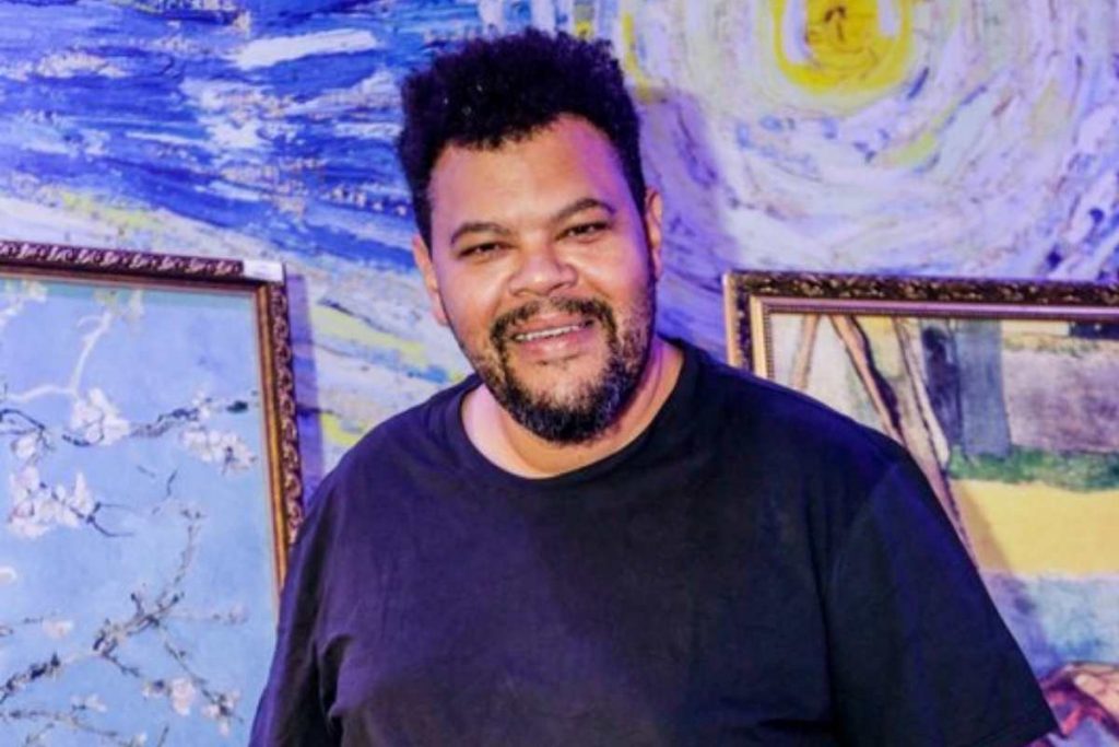 Babu Santana posando para foto em exposição do Van Gogh