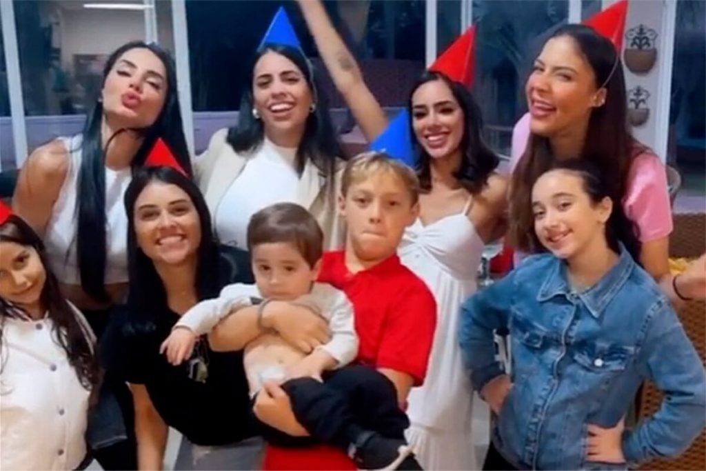 Bruna Biancardi e várias mulheres de chapeuzinho de festa infantil, na comemoração do aniversário de Davi Lucca