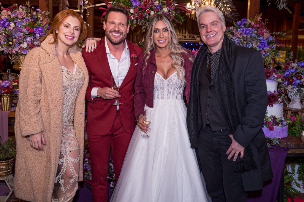 Deborah Albuquerque de casaco de renda bege, vestido curto branco, Bruno Salomão de preto com os noivos