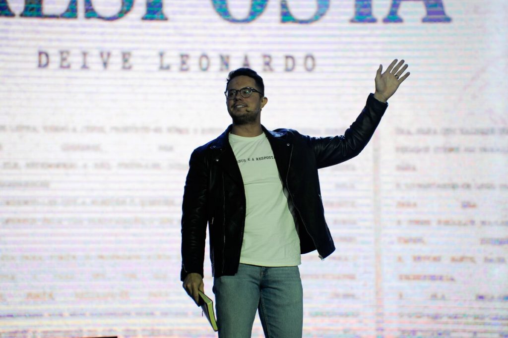 Deive Leonardo de jaqueta preta e camisa branca, de óculos de grau