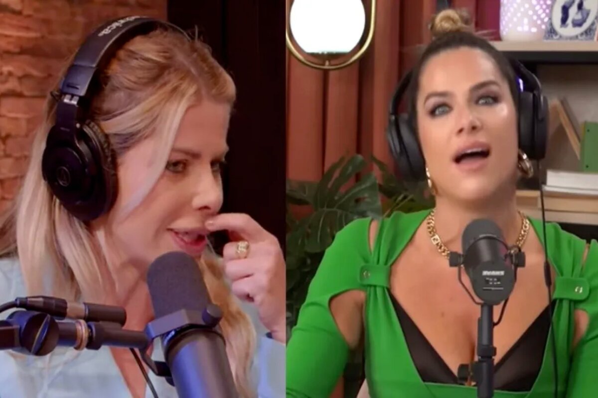 Karina Bacchi de blusa roxa e Giovanna Ewbank de verde, ambas com fone de ouvido, de frente para o microfone, em seus respectivos estúdios de podcast