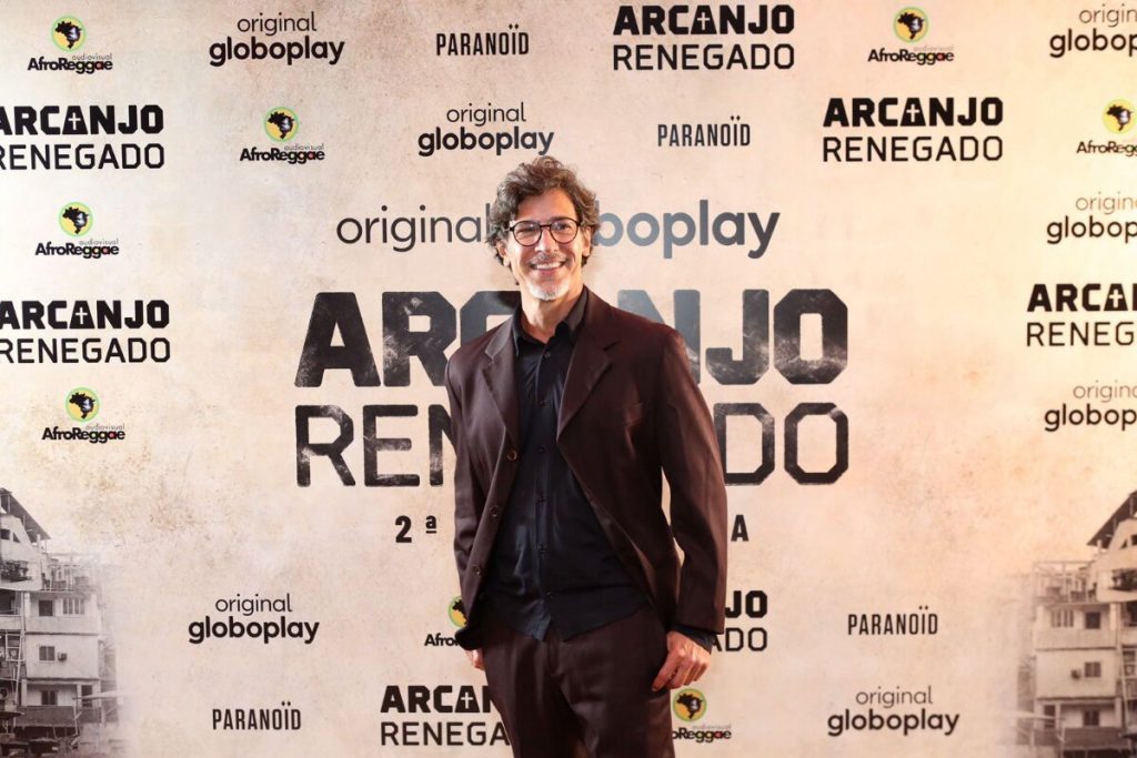 Leonardo Brício todo de preto, posando no backdrop de Arcanjo Renegado