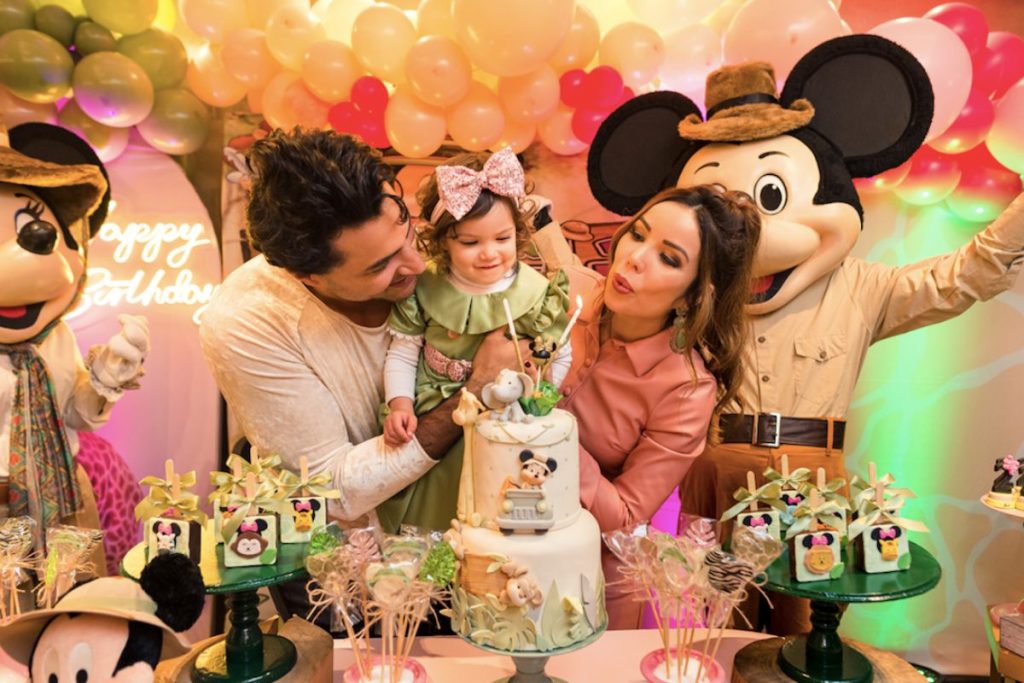 Liah Soares e Carlo Porto assoprando a vela do bolo de aniversário com a filha