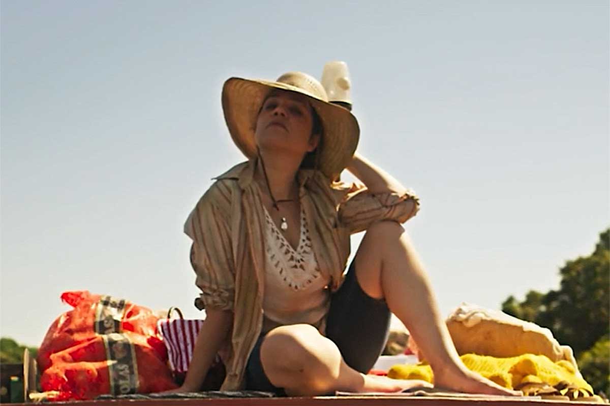 Maria bruaca (Isabel Teixeira) sentada em cima da Chalana, em Pantanal