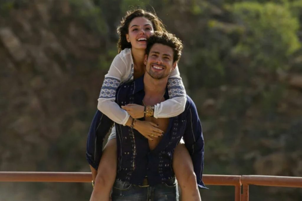 Isis Valverde sendo levada nas costas por Cauã Reymond, em cena da série Amores Roubados