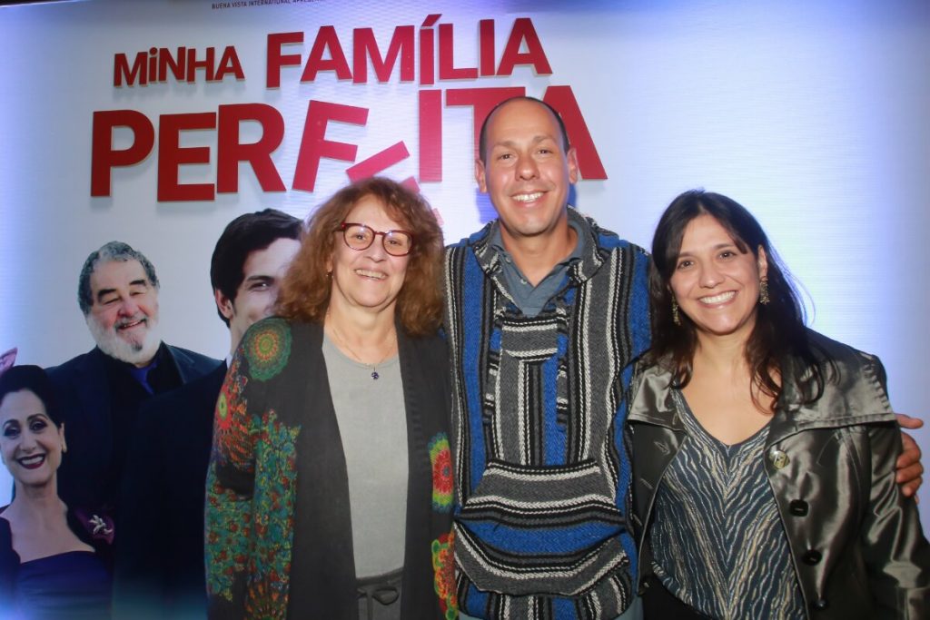 Ana Maria Moretzshon e os filhos, Guga Coelho e Patrícia Moretzshon  abraçados e sorrindo 