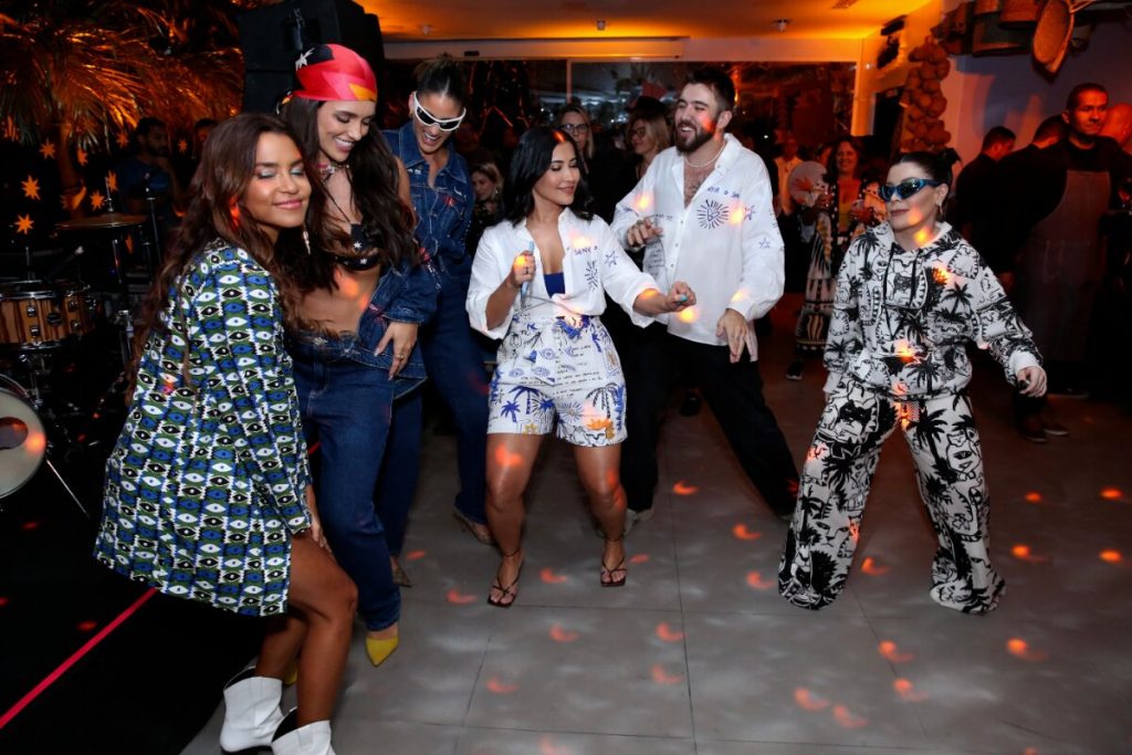 Lucy Alves de estampa verde e branca, pernas de fora, Rafa Kalimann de jeans e bandana, Thaynara OG de conjunto branco estampado, GKay de macacão branco estampado, todas dançando