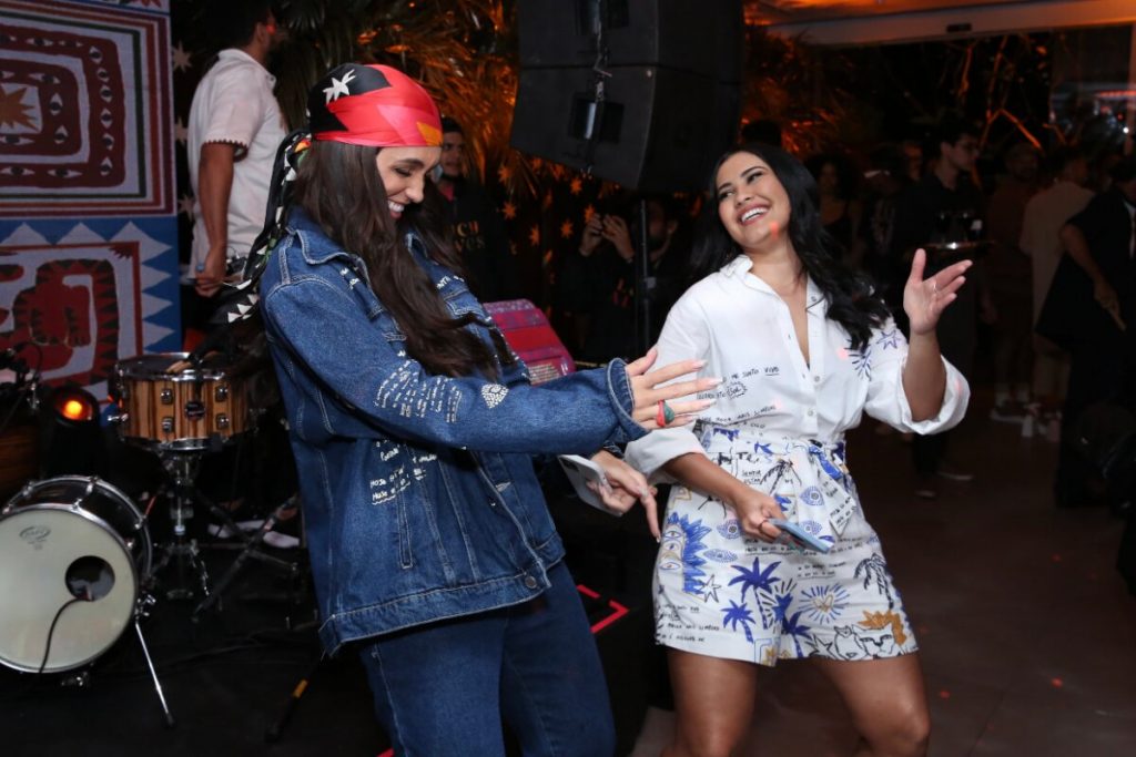 Rafa Kalimann de jeans e bandana vermelha, dançando com Thaynara OG, que veste branco com estampa azul