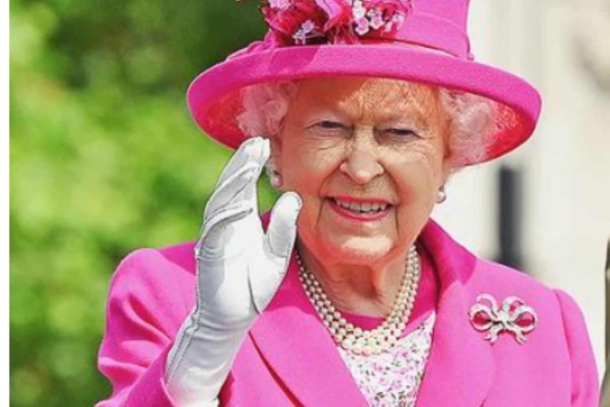 Rainha Elizabeth II de roupa e chapéu rosa forte e acenando