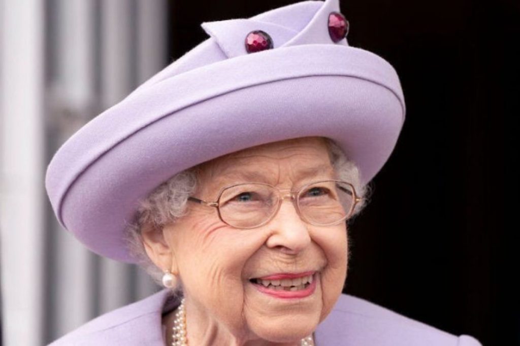 Rainha Elizabeth, sorridente, de chapéu lilás