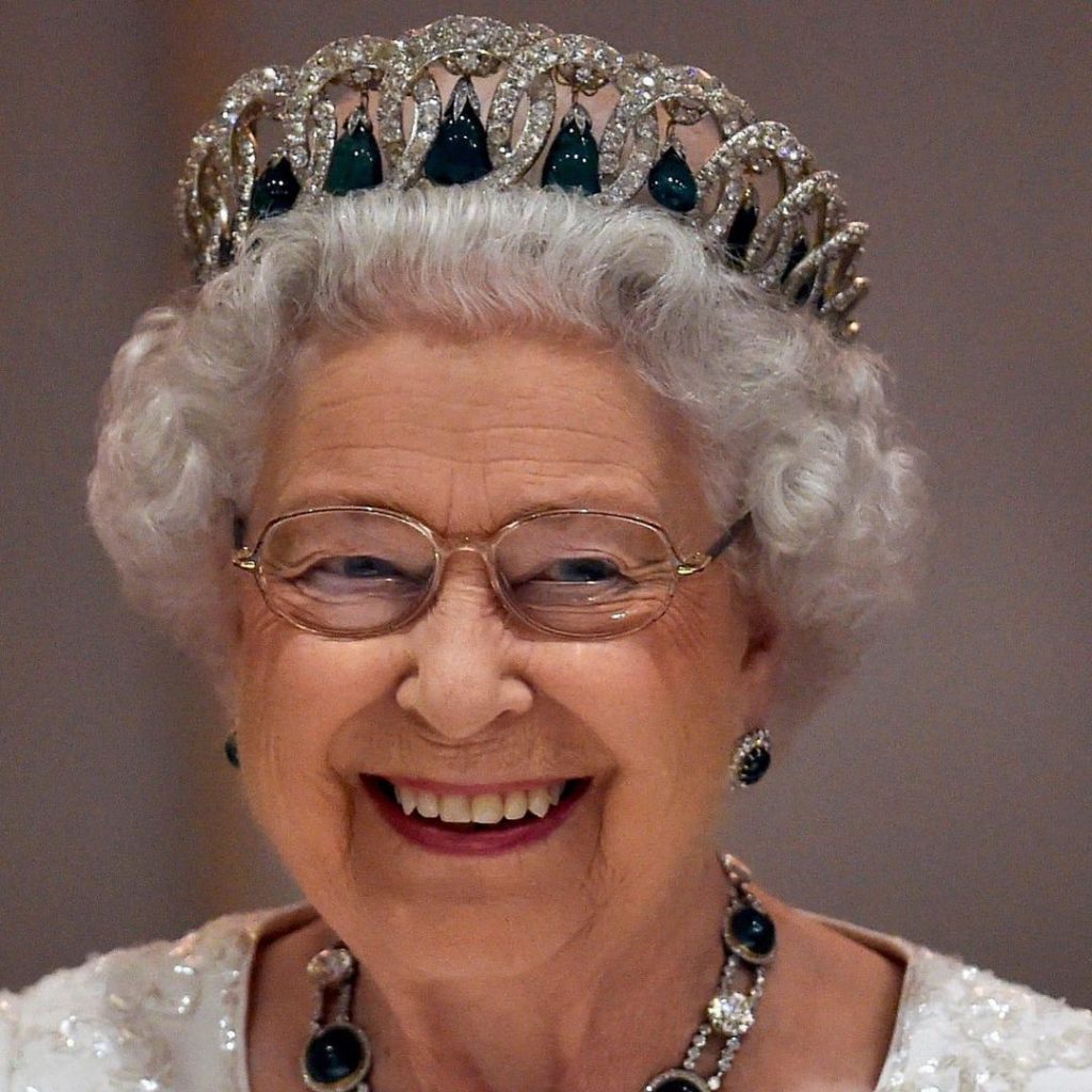 Rainha Elizabeth II com coroa de esmeraldas e diamantes, sorridente