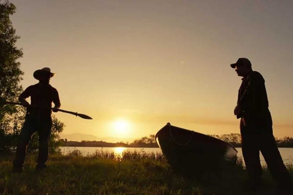 Alcides (Juliano Cazarré) segurando zagaia na frente de Tenório (Murilo Benício) em Pantanal