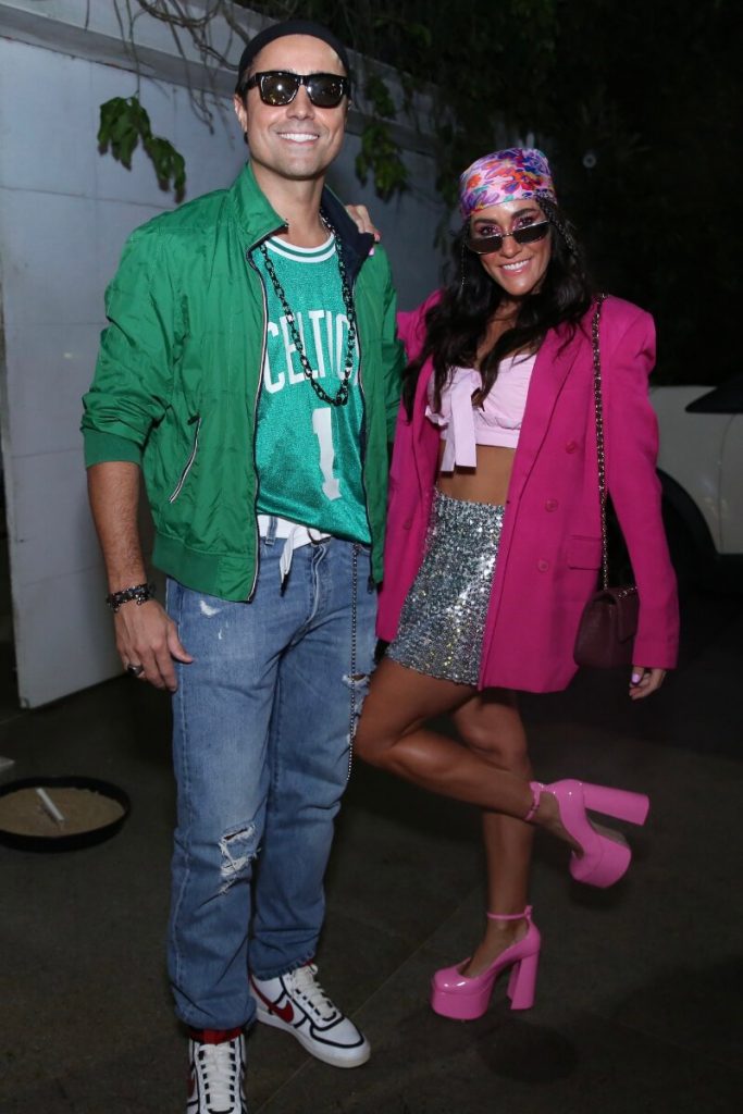 Ricardo Pereira de camisa e jaqueta verde e a mulher, Francisca Pinto, de saia prata, cropped, casado e sapato rosa e 