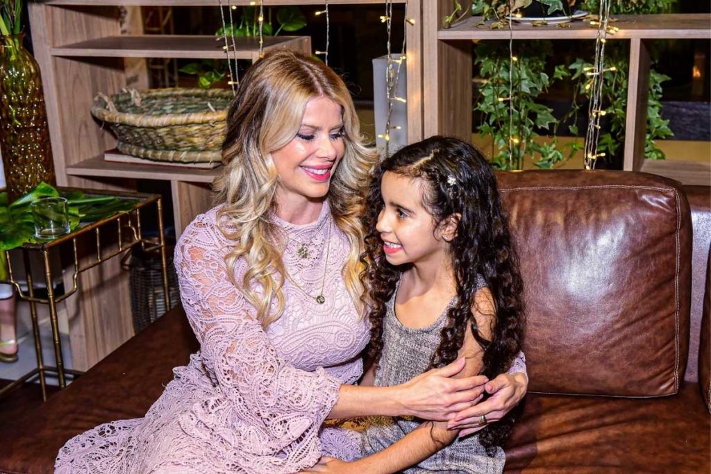 Karina Bacchi posando com criança em evento da ONG Florescer