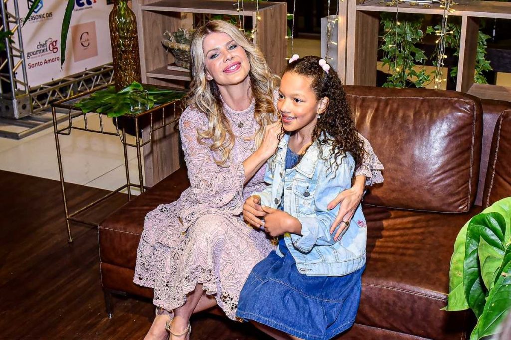 Karina Bacchi posando com criança em evento da ONG Florescer