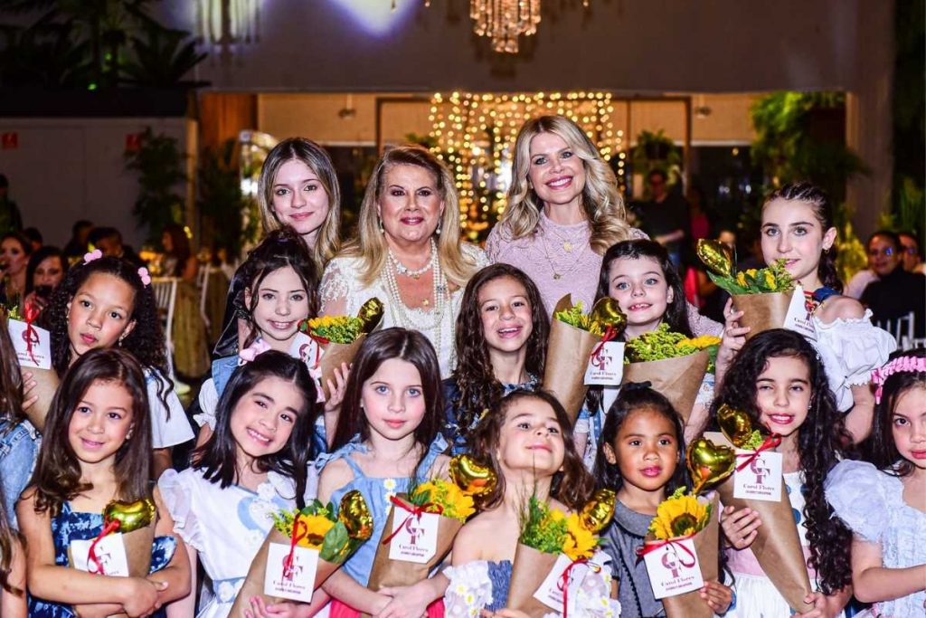 Karina Bacchi posando com crianças em evento da ONG Florescer