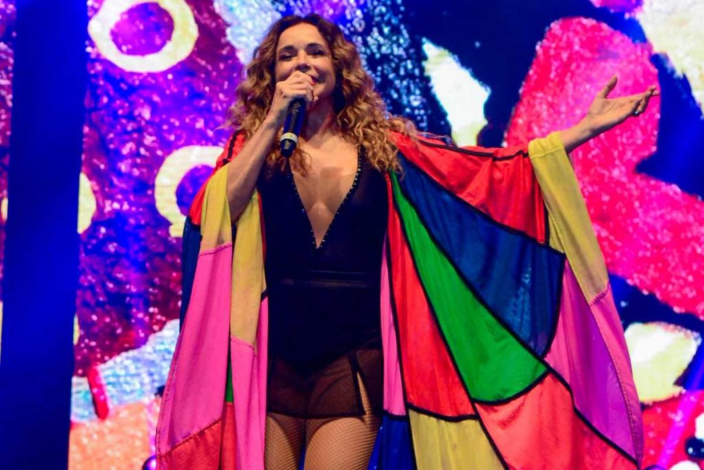 Daniela Mercury com bandeira LGBTQIAPN+ se apresentando no Village Betano