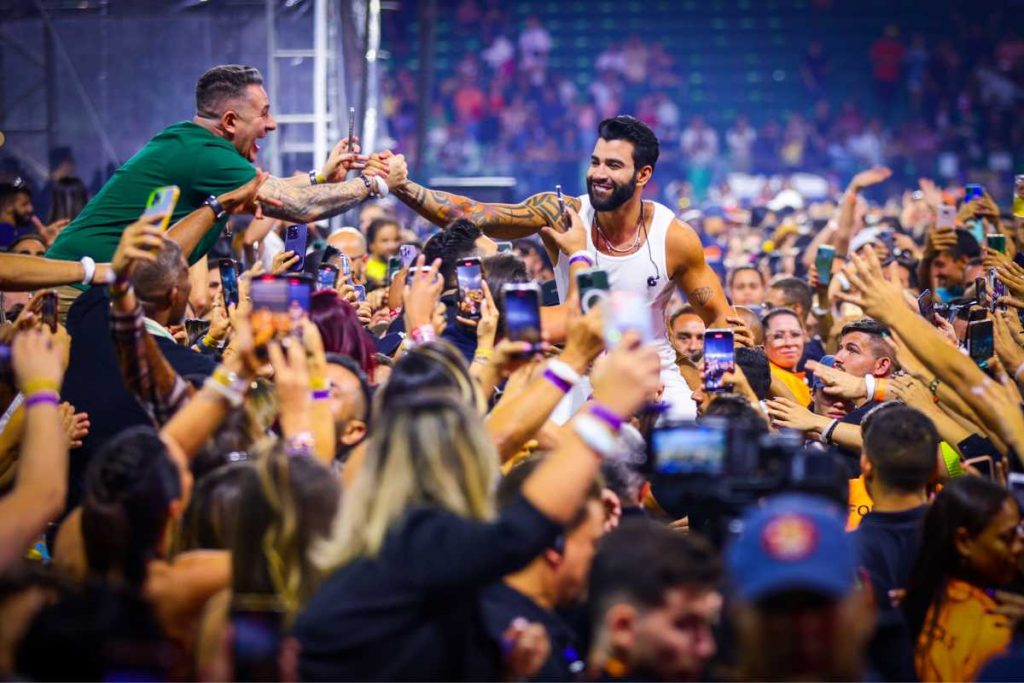 Gusttavo Lima se jogando nos fãs em show no festival Buteco