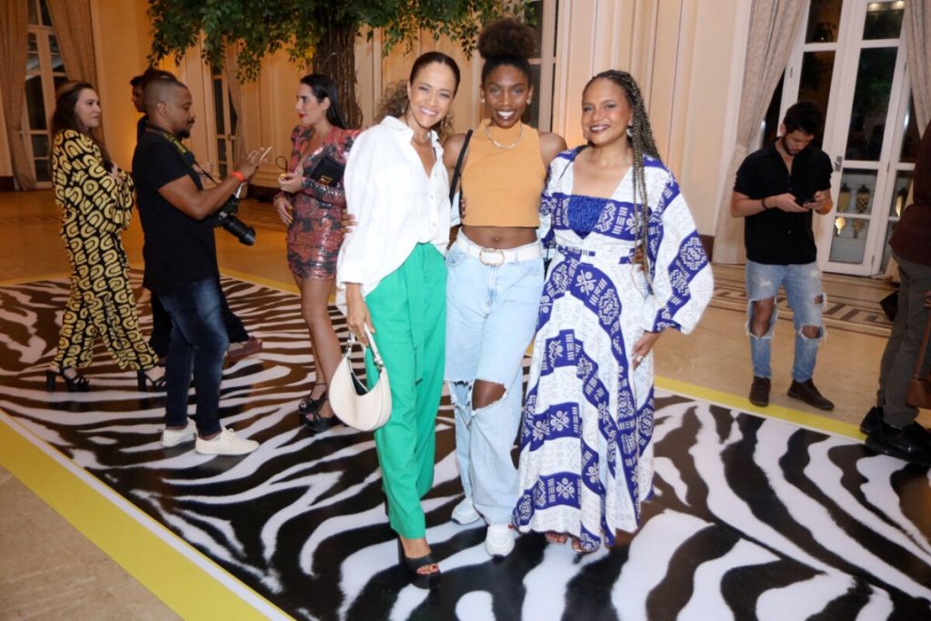 Aline Borges à esquerda, Késia Estácio ao centro e Teresa Cristina à direita, abraçadas, sorrindo