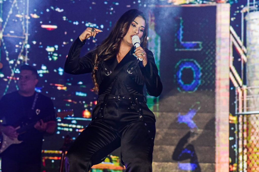 Simone Mendes no palco, de calça e camisa preta 