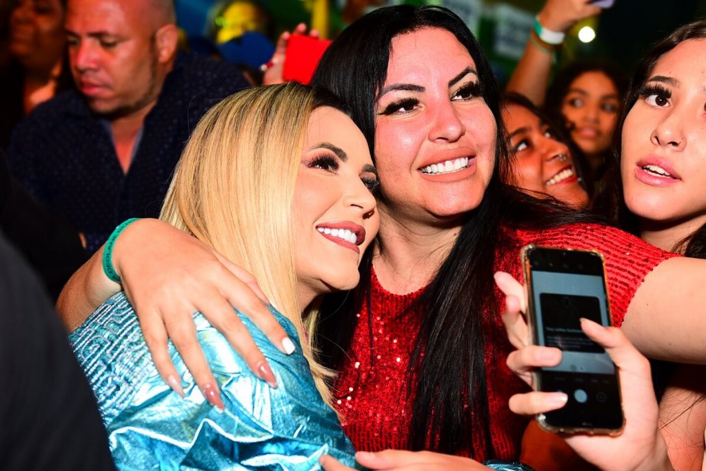 Deolane abraçada a uma fã, fazendo selfie