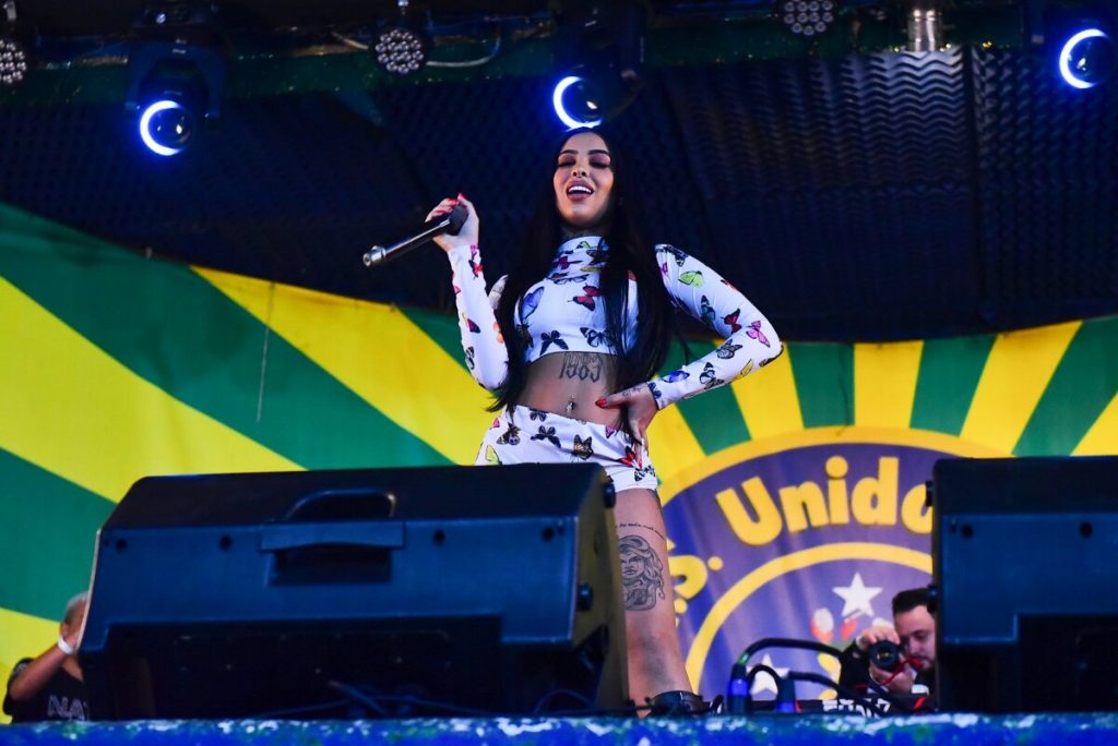 DJ Nathi no palco, segurando microfone