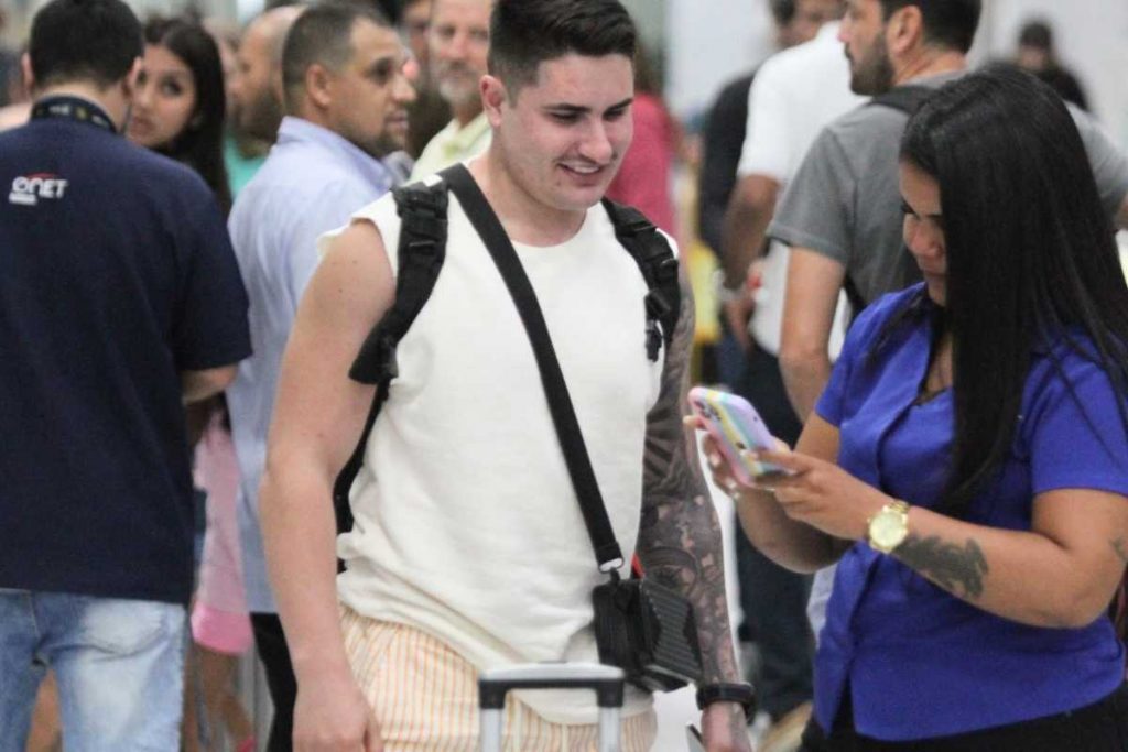 Lucas Souza tirando foto com fãs no aeroporto