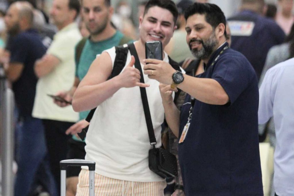 Lucas Souza tirando foto com fãs no aeroporto