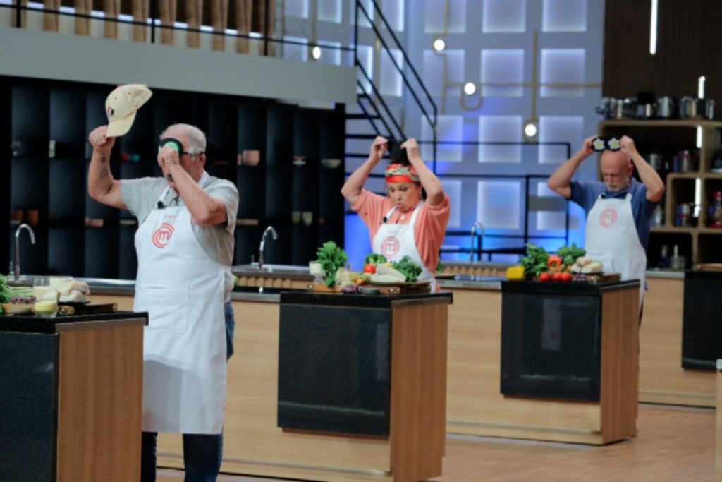 Participantes torando a venda dos olhos, nas bancadas