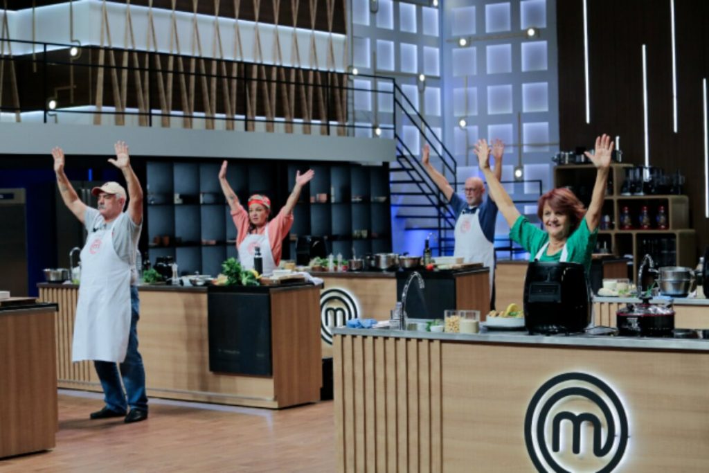 Participantes nas bancadas, com os braços pra cima