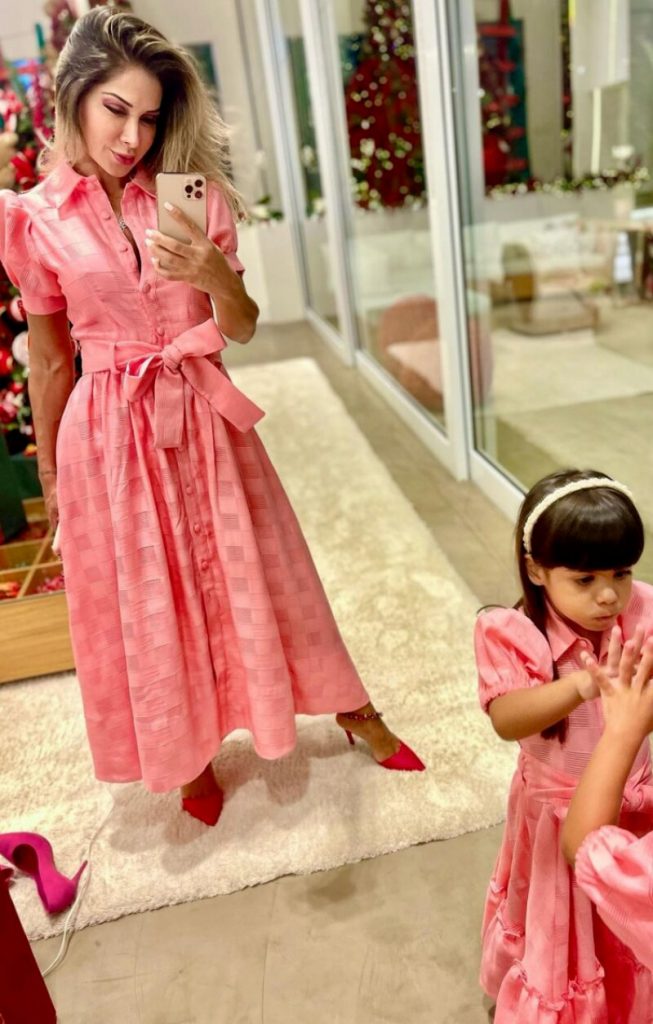 Maira fazendo foto de Sophia ambas de vestido cor de rosa 