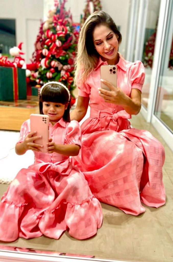 Maira fazendo selfie com Sophia, ambas de vestido cor de rosa 