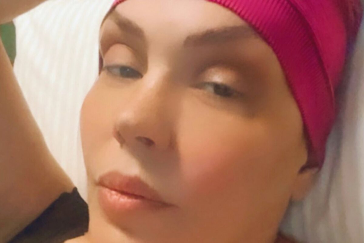 Simony na cama de hospital com uma touca rosa
