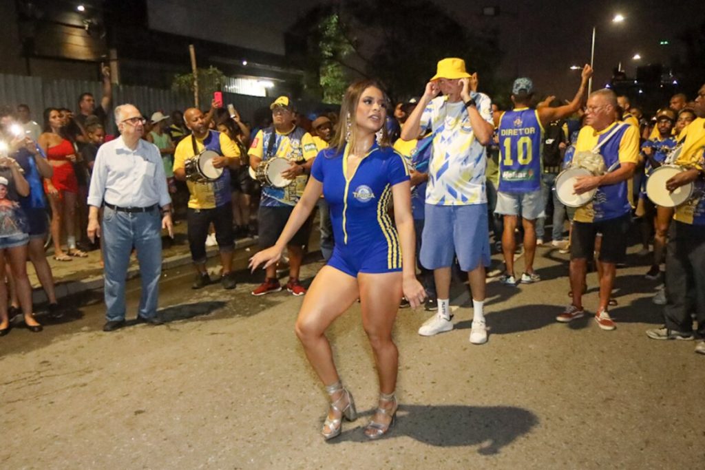 Lexa de macaquinho azul com listras laterais amarela e fecho eclair frontal