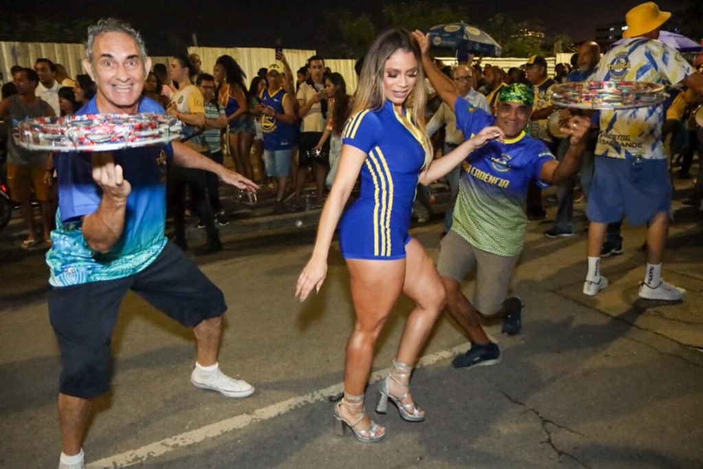 Lexa de macaquinho azul com listras laterais amarela e fecho eclair frontal