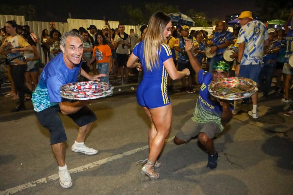 Lexa de macaquinho azul com listras laterais amarela e fecho eclair frontal