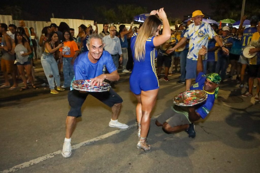 Lexa de macaquinho azul com listras laterais amarela e fecho eclair frontal