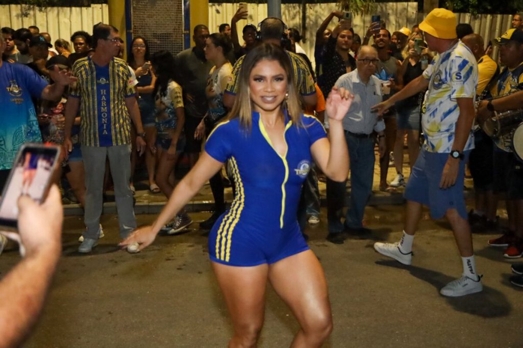 Lexa de macaquinho azul com listras laterais amarela e fecho eclair frontal