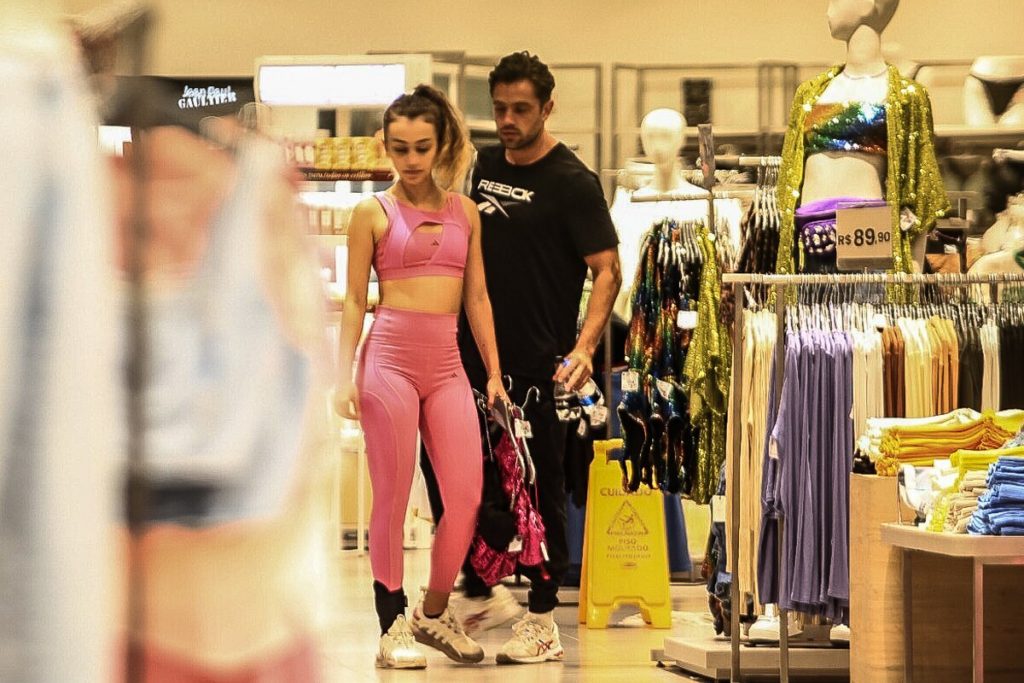 Rafael Cardoso de camisa preta e a namorada, Vivian Linhares, de top e legging rosa