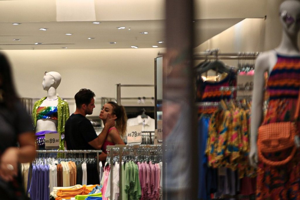Rafael Cardoso de camisa preta e a namorada, Vivian Linhares, no shopping